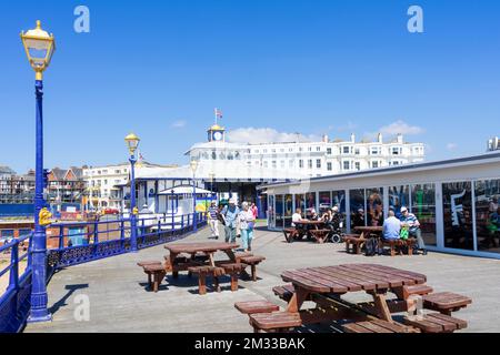 Eastbourne East Sussex Menschen, die am Eastbourne Pier spazieren und vor dem Café am Eastbourne Pier sitzen Eastbourne East Sussex England GB Europe Stockfoto