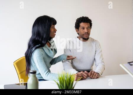 afroamerikanisches Paar, das für eine Paartherapie in der Praxis eines Psychologen sitzt - Beziehungskonzept in Schwierigkeiten und Krise - Fokus auf männerfoto Stockfoto