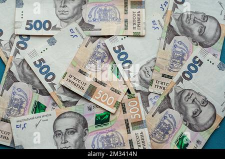 Geld Bargeld ukrainische Hrywna fünfhundert Hrywna Tausend Scheine und Münzen Geld verdienst Konzept Dollars auf blauem Hintergrund Stockfoto