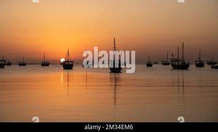 Traditionelle arabische Dhows an der Küste während des Sonnenaufgangs in Katar Stockfoto