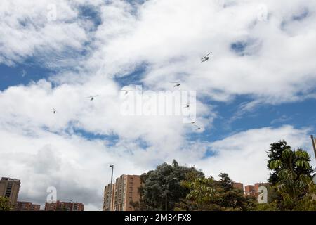 Acht Helikopter fliegen über Wohngebäude während der kolumbianischen Unabhängigkeitstagsparade der Streitkräfte. Stockfoto