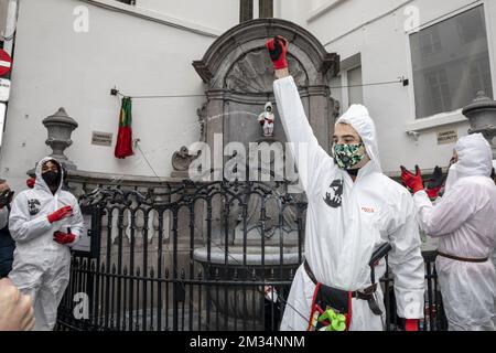 Das Abbildungsbild zeigt „Covid Boys“ in weißen Schutzanzügen während einer Zeremonie, bei der das erste neue Kostüm von 2021 von Brussels berühmtester Statue Manneken Pis in Brüssel am Donnerstag, den 18. März 2021, enthüllt wird. Er erhält ein Outfit der „Covid Boys“, d. h. junge Männer, die in Schutzanzügen durch das Stadtzentrum von Brüssel laufen, Handdesinfektionsmittel, Klebebänder und Schwämme mit sich herumtragen und Humor einsetzen, um die Menschen in der anhaltenden Coronavirus-Krise zu ermutigen, die Hygienevorschriften einzuhalten. Der 18. März ist ein Jahr seit Beginn der ersten Abriegelung. BELGA FOTO HATIM KAGHAT Stockfoto