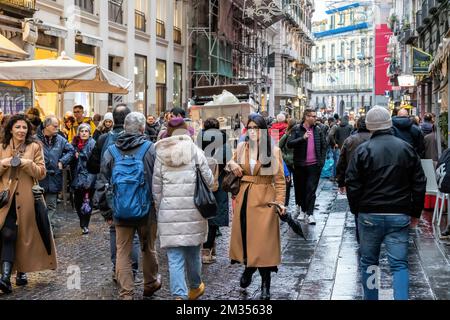 Neapel, Italien - 10. Dezember 2022: An einem regnerischen Tag spazieren die Leute über Toledo, die Straße ist vor Weihnachten überfüllt. Stockfoto