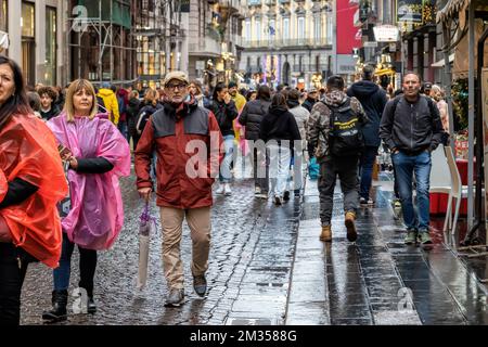 Neapel, Italien - 10. Dezember 2022: An einem regnerischen Tag spazieren die Leute über Toledo, die Straße ist vor Weihnachten überfüllt. Stockfoto