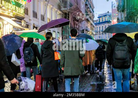 Neapel, Italien - 10. Dezember 2022: An einem regnerischen Tag spazieren die Leute über Toledo, die Straße ist vor Weihnachten überfüllt. Stockfoto