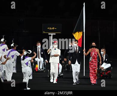 Der Torballspieler Bruno Vanhove und der belgische Jockey Michele George halten während der Eröffnungszeremonie der Paralympischen Spiele 2020 in Tokio, am Dienstag, den 24. August 2021, die belgische Flagge. Die paralympischen Spiele finden vom 24. August bis zum 5. September statt. BELGA-FOTO Stockfoto