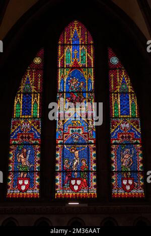 A vertical shot of a stained glass window of the Freiburger Munster cathedral in Germany. Stock Photo