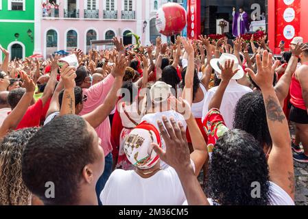 Salvador, Bahia, Brasilien - 04. Dezember 2022: Gläubige Katholiken von Santa Barbara erheben ihre Waffen zum Himmel zu Ehren des Weihnachtsmanns. Pelourinho, Salvador, Ba Stockfoto