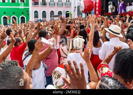 Salvador, Bahia, Brasilien - 04. Dezember 2022: Gläubige Katholiken von Santa Barbara erheben ihre Waffen zum Himmel zu Ehren des Weihnachtsmanns. Pelourinho, Salvador, Ba Stockfoto