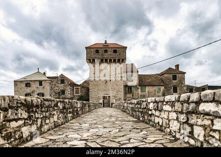 Festung Kaštilac in Kaštel Gomilica, Kroatien. Steinbrücke und Turm mit Eingang in die alte Burg. Stockfoto