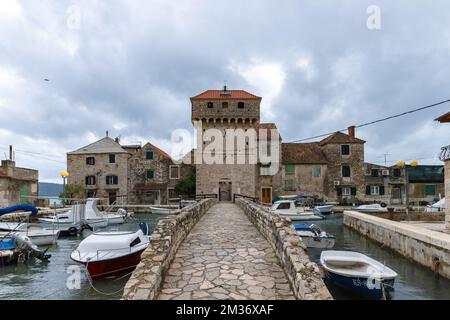 Festung Kaštilac in Kaštel Gomilica, Kroatien. Steinbrücke und Turm mit Eingang in die alte Burg. Stockfoto