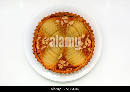 Süße französische Birnen- und Mandeltörtchen auf weißem Teller und Hintergrund Stockfoto