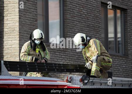 Abbildung zeigt Rettungsarbeiter, die am Freitag, den 31. Dezember 2021, eine Leiter auf dem Dach eines Feuerwehrfahrzeugs am Standort einer Explosion in einem fünfgeschossigen Apartmentgebäude im Zentrum von Turnhout vorbereiten. Eine Person wurde bereits ins Krankenhaus gebracht. Eine Person befindet sich unter dem Trümmer. Vier Einwohner werden vermisst. BELGA FOTO KRISTOF VAN ACCOM Stockfoto