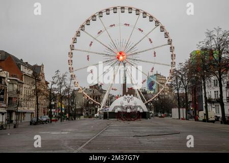 Abbildung zeigt das Riesenrad (Groot Rad - Grande Roue) auf dem leeren Vismarkt - Marche aux Poissons, am Neujahrstag, Samstag, den 01. Januar 2022 in Brüssel. Die Stände des Weihnachtsmarktes wurden alle entfernt, als die Stadt beschloss, die Ereignisse Winterpret - Plaisirs d'Hiver nach schwerwiegenderen Einschränkungen in der laufenden Corona-Virus-Pandemie zu schließen. BELGA FOTO HATIM KAGHAT Stockfoto