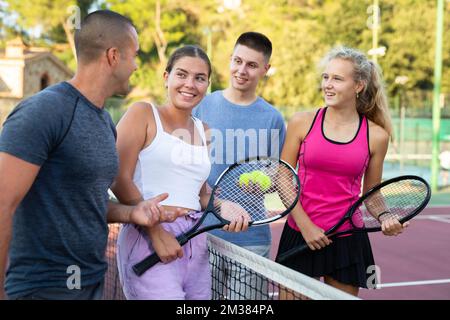 Vier Tennisspieler stehen auf dem Platz und reden über Match Stockfoto