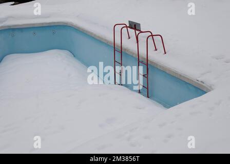 Gefrorenes Schwimmbad mit Boardleiter Stockfoto