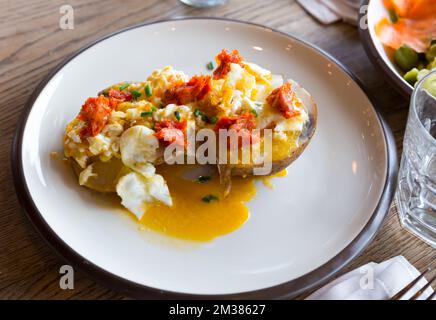 Gegrillte Kartoffel mit würziger Wurstpastete und Eiern, auf dem Teller Stockfoto