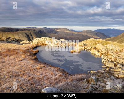 A frozen tarn on Glaramara, Lake District, UK. Stock Photo