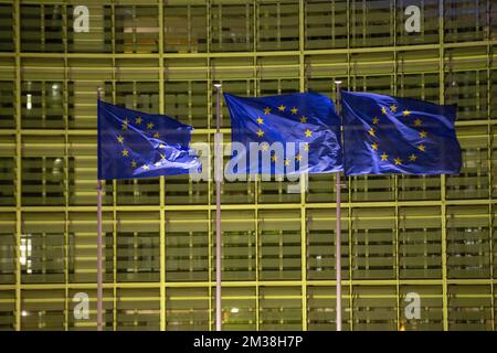 Abbildung zeigt europäische Flaggen vor dem Berlaymont-Gebäude, in dem sich der Sitz der Europäischen Kommission befindet, der in den Farben der ukrainischen Flagge beleuchtet ist, um die Unterstützung der ukrainischen Bevölkerung zu zeigen, am Donnerstag, den 24. Februar 2022 in Brüssel. Gestern Abend beschloss Russland, mehrere ukrainische Regionen zu überfallen. BELGA FOTO NICOLAS MAETERLINCK Stockfoto