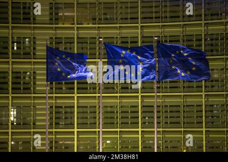 Abbildung zeigt europäische Flaggen vor dem Berlaymont-Gebäude, in dem sich der Sitz der Europäischen Kommission befindet, der in den Farben der ukrainischen Flagge beleuchtet ist, um die Unterstützung der ukrainischen Bevölkerung zu zeigen, am Donnerstag, den 24. Februar 2022 in Brüssel. Gestern Abend beschloss Russland, mehrere ukrainische Regionen zu überfallen. BELGA FOTO NICOLAS MAETERLINCK Stockfoto