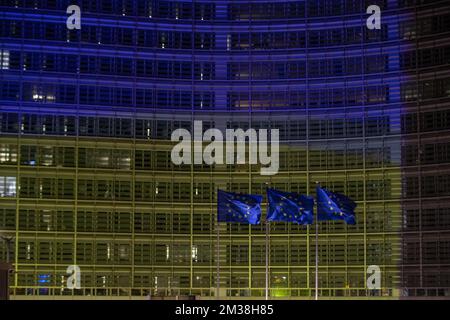 Abbildung zeigt europäische Flaggen vor dem Berlaymont-Gebäude, in dem sich der Sitz der Europäischen Kommission befindet, der in den Farben der ukrainischen Flagge beleuchtet ist, um die Unterstützung der ukrainischen Bevölkerung zu zeigen, am Donnerstag, den 24. Februar 2022 in Brüssel. Gestern Abend beschloss Russland, mehrere ukrainische Regionen zu überfallen. BELGA FOTO NICOLAS MAETERLINCK Stockfoto