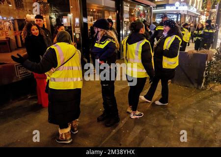 ROTTERDAM - Freiwillige und Polizei mit marokkanischen Fußballfans nach dem Halbfinalspiel zwischen Marokko und Frankreich bei der Weltmeisterschaft in Katar. ANP JEFFREY GROENEWEG Stockfoto