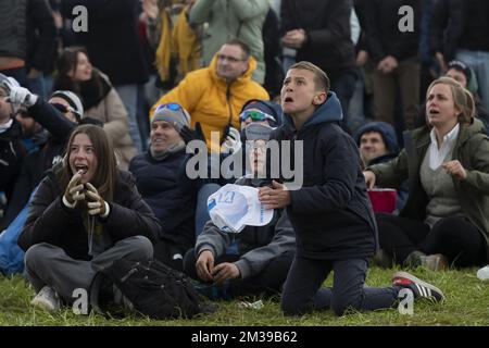 Ein Junge reagiert, während Radfans den Endspurt auf einer riesigen Leinwand beim Oude Kwaremont Kopfsteinpflasterklettern in Kluisbergen verfolgen, während des Herrenrenrenrennen „Ronde van Vlaanderen - Tour des Flandres - Tour of Flanders“ eintägiges Radrenrennen, 272,5km km von Antwerpen nach Oudenaarde, Sonntag, 03. April 2022. BELGA FOTO KRISTOF VAN ACCOM Stockfoto