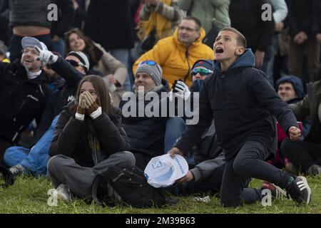 Ein Junge reagiert, während Radfans den Endspurt auf einer riesigen Leinwand beim Oude Kwaremont Kopfsteinpflasterklettern in Kluisbergen verfolgen, während des Herrenrenrenrennen „Ronde van Vlaanderen - Tour des Flandres - Tour of Flanders“ eintägiges Radrenrennen, 272,5km km von Antwerpen nach Oudenaarde, Sonntag, 03. April 2022. BELGA FOTO KRISTOF VAN ACCOM Stockfoto