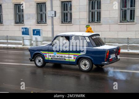 Ein Trabant-Auto aus Berlins Trabi World fährt vorbei. Rauchige Emissionen sind am Auspuffrohr des Fahrzeugs zu erkennen Stockfoto