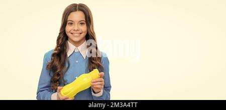 Happy Hungry Mädchen halten gelbe Plastikflasche mit Trinkjoghurt für gesundes Frühstück Mahlzeit, Hunger. Horizontales Poster mit isoliertem Kindergesicht, Banner Stockfoto