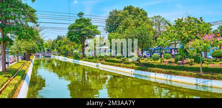 BANGKOK, THAILAND - 23. APRIL 2019: Panoramablick auf den engen üppigen Park mit Blumenbeeten und dem Rop Krung Canal, am 23. April in Bangkok, Thailand Stockfoto