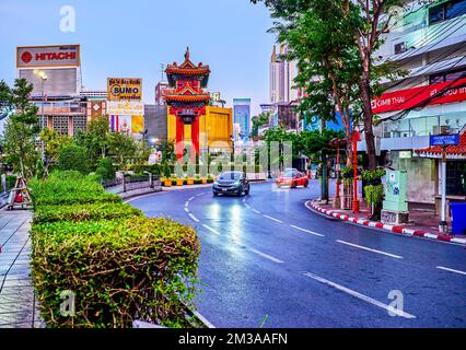 BANGKOK, THAILAND - 23. APRIL 2019: Farbenfrohes Chinatown Tor, mit mehrfarbigem Dach, schlanken Säulen und Schnitzereien, umgeben von einem Topiary Park in Tri mit Stockfoto