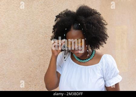 Junge Latina mit Afrohaar, lachend im Park Stockfoto
