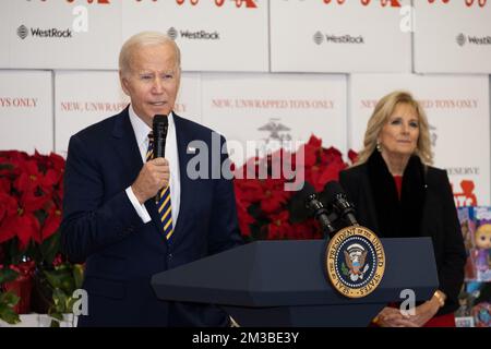 Arlington, United States. 12 December, 2022. U.S. President Joe Biden delivers remarks as First Lady Jill Biden, right, looks on during the 75th anniversary Toys for Tots sorting at Joint Base Myer-Henderson Hall, December 12, 2022 in Arlington, Virginia.  Credit: Sgt. Ellen Schaaf/US Marine Corps/Alamy Live News Stock Photo