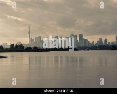 Herbsttagesblick über die inneren Buchten des Lake Ontario im Tommy Thompson Park mit nebeliger Skyline der Innenstadt von Toronto unter grauem, bewölktem Himmel im Hintergrund Stockfoto