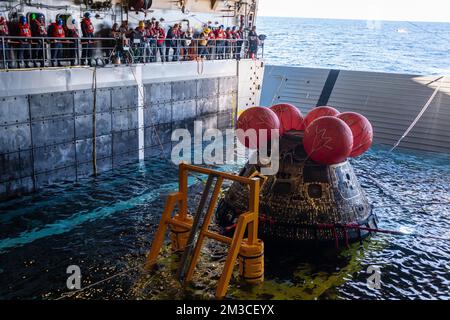 Pacific Ocean. 11th Dec, 2022. Sailors aboard amphibious transport dock USS Portland (LPD 27) use a line load attenuating mechanism assembly to pull the NASA Artemis I Orion spacecraft into the well deck. Portland, along with Independence-variant littoral combat ship USS Montgomery (LCS 8), is underway in U.S. 3rd Fleet in support of the recovery. The retrieval operation is part of a Department of Defense effort that integrates combatant command service capabilities to determine best practices for safely retrieving spacecraft capable of carrying humans into space. The U.S. Navy has many u Stock Photo