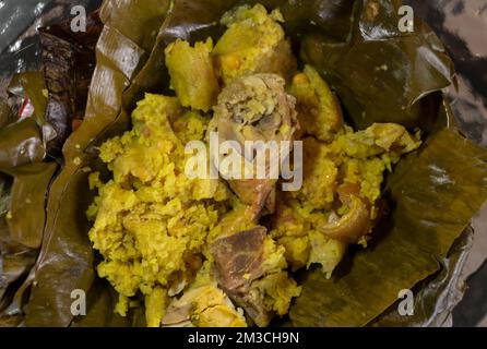 Aus nächster Nähe ein typisch kolumbianisches Essen namens „Tamal“. Eine Mischung aus Reisschweinebohnen und Huhn, in Bananenblätter eingewickelt. Essen und Sackgasse Stockfoto