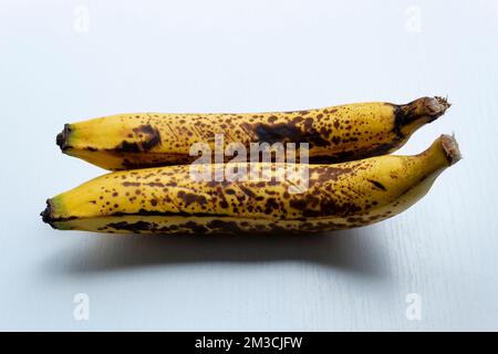 Schließen Sie zwei gelbe Sommersprossen in horizontaler Form über einem weißen Holztisch. Stockfoto