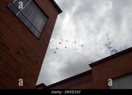 Kriegsflugzeuge in V-Formation fliegen über einer Wohneinheit mit wolkenlosem grauen Himmel im Hintergrund am kolumbianischen Unabhängigkeitstag Stockfoto