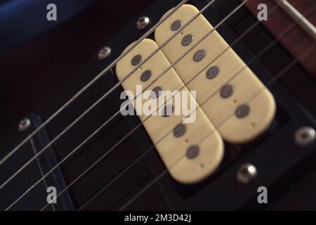 Schließen wir uns zu sechs elektrischen Gitarrensaiten, Holzfottafel und Mikrofonen zusammen. Instrumente und Musikkonzept Stockfoto