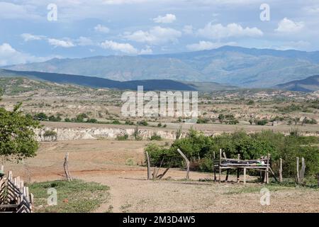 Bei Sonnenuntergang gibt es eine Farm mit artesanalen Zäunen und Bergen und Wolken in der Tatacoa-Wüste, Huila, Kolumbien. Stockfoto