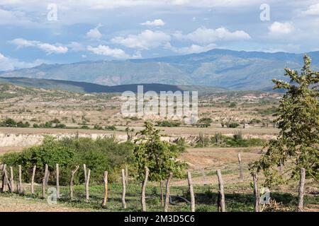 Bei Sonnenuntergang gibt es eine Farm mit artesanalen Zäunen und Bergen und Wolken in der Tatacoa-Wüste, Huila, Kolumbien. Stockfoto