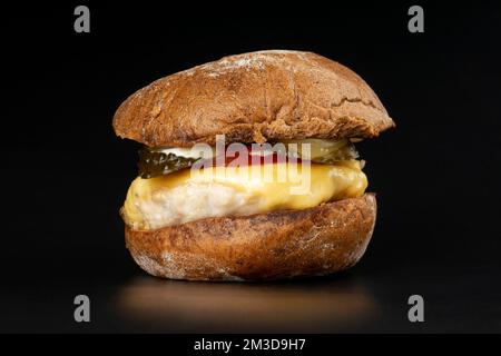 Saftiger Burger mit braunem Brötchen, Cheeseburger mit Hühnerschnitzel, Käse und Gemüse auf dunklem Hintergrund. Stockfoto