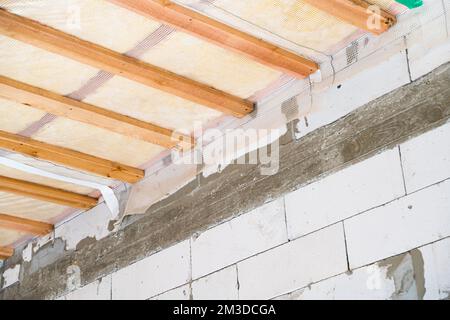 Isolierte Decke eines Privathauses mit einer Holzkiste. Das Dach ist mit  Glaswolle isoliert und mit einer Dampfsperre ummantelt, Ansicht von unten  Stockfotografie - Alamy