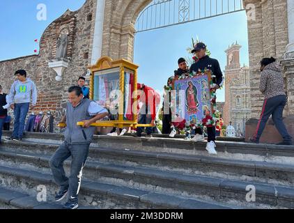 Cholula, Puebla, USA. 10.. Dezember 2022. Die Ehrungen an Maria (Unsere Lieben Frau von) Guadalupe werden von der Kirche San Francisco Acatepec in Cholula, Mexiko, nahe Puebla, nach ihrer Segnung am Samstag, den 10. Dezember 2022 getragen. Tausende von Pilgern begeben sich jedes Jahr zur Basilika unserer Lieben Frau von Guadalupe in Mexiko-Stadt, um am 12. Dezember eine Feier zu feiern. (Kreditbild: © Mark Hertzberg/ZUMA Press Wire) Stockfoto