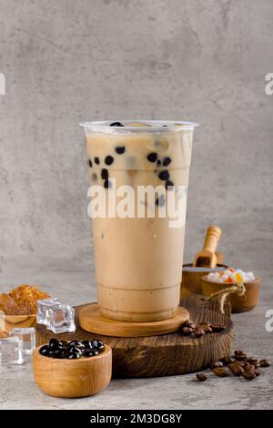 Boba oder Tapioka Perlen ist taiwan Bubble Milchtee in Kunststoff-Tasse mit Milchtee-Geschmack auf Textur Hintergrund, Sommer Erfrischung. Stockfoto