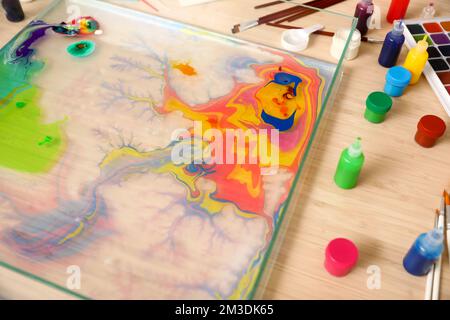 Behälter mit Wasser und Farben für Ebru auf dem Tisch in der Werkstatt, Nahaufnahme Stockfoto