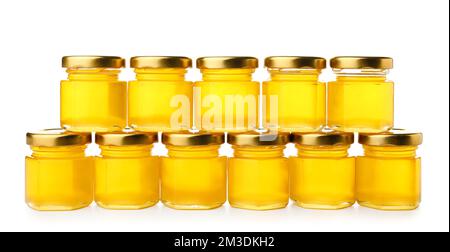 Gläser mit köstlichem Honig isoliert auf weißem Hintergrund Stockfoto