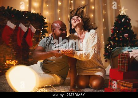 Geschenk Happy interrasscial couple Celebrate Silvester Christmas at Home Opening Geschenke Stockfoto