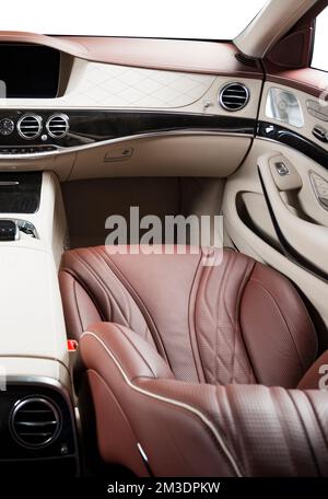 Moderner Luxus-Innenraum – Lenkrad, Schalthebel und Armaturenbrett. Luxus im Fahrzeuginnenraum. Beige bequeme Sitze, Lenkrad, Armaturenbrett, Geschwindigkeit Stockfoto